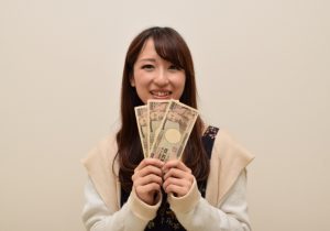 3万円を見せる女性