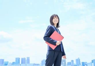 青空を背にしたビジネスウーマン